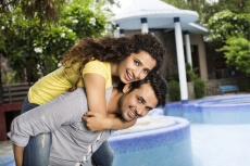 man carrying woman on back outside villa