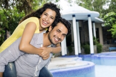 man carrying woman on back outside villa