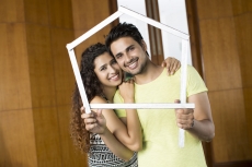 couple posing with house shaped frame