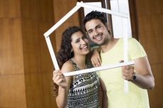 couple posing with house shaped frame