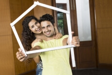 couple posing with house shaped frame