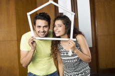 couple posing with house shaped frame
