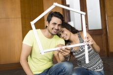 couple posing with house shaped frame