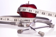 red apple wrapped with a tape and a stethoscope