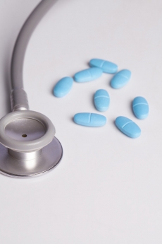 medical pills and stethoscope on white background