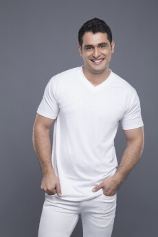 man in white standing with hands in pockets 