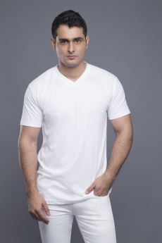 man in white standing with hands in pockets 