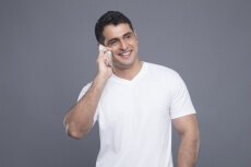 man in white t shirt talking on phone 