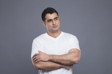 man in white with hands folded