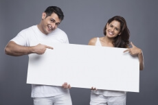 young couple holding a blank poster