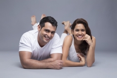 attractive young couple smiling at the camera on a white background