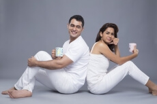 couple sitting back to back talking and smiling at camera