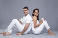couple sitting back to back talking and smiling at camera