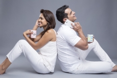 couple talking on the phone while drinking coffee