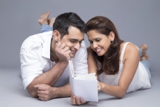 couple reading a book while lying in front view