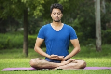 boy performing yoga in parK