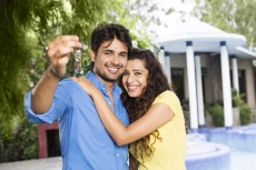 couple showing home keys outside the villa