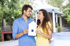 couple showing home cutout outside villa