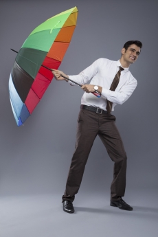 man in formal clothes posing with an umbrella 