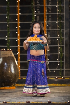 sweet girl holding a thali of laddu on diwali