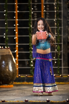 cheerful small girl offering a present on diwali