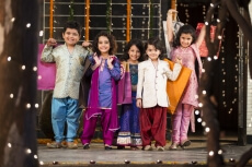 five small kids dressed in traditional outfit holding shopping bags