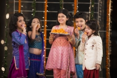 group of kids eating laddu on diwali