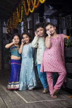 kids in traditional wear talking on phone 