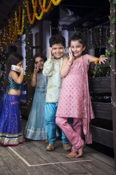 kids in traditional wear talking on phone 