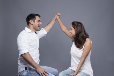 couple sitting and posing by making a heart 