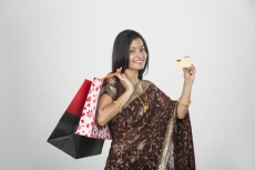 woman in saree with credit card and shopping bags 