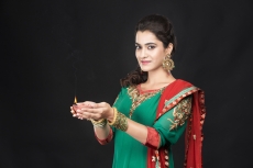 girl in traditional wear posing with diya