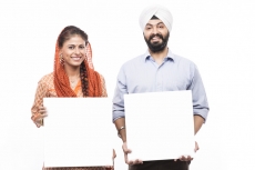 sikh couple standing with a message board 