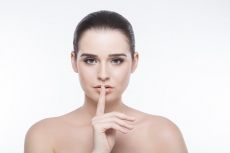 girl posing with finger on her lips