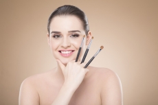 girl posing with make up brush and smiling