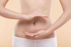 girl make healthcare gesture on her stomach 