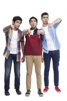 three friends posing with thumbs down gesture