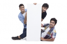 three friends posing with placard