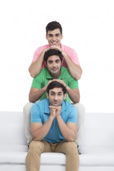 three young friends sitting in a row and posing 