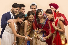 group of indian people lighting up diya