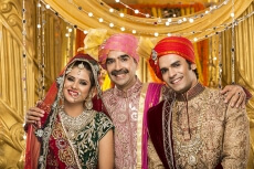 bride and groom posing with father 