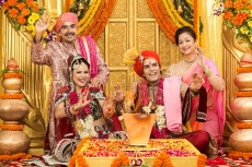 indian bride and groom sitting with parents at mandap
