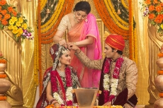 groom applying sindoor to wife