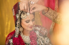 groom applying sindoor to wife