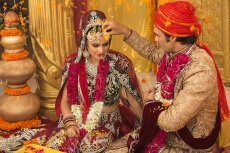 groom applying sindoor to wife