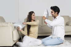 couple pillow fighting at home