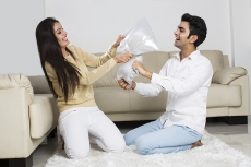 couple pillow fighting at home