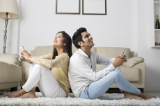 couple at home chatting on mobile phone