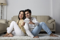 couple clicking picture with mobile phone at home