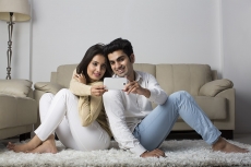 couple clicking picture with mobile phone at home